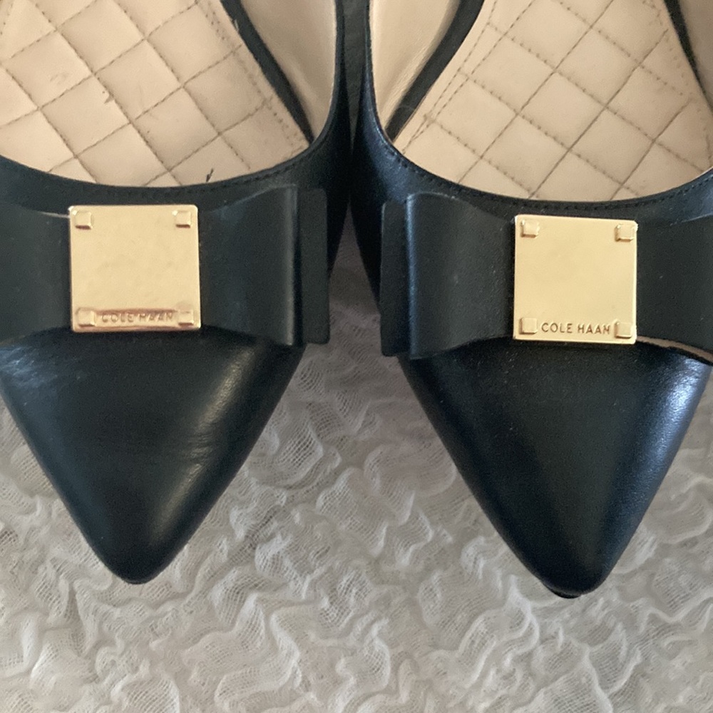Like new Cole Haan black leather flats with bow and gold Cole Haan logo on toe